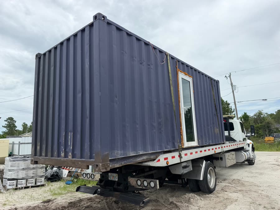 20-foot shipping container loaded on the flatbed tow truck