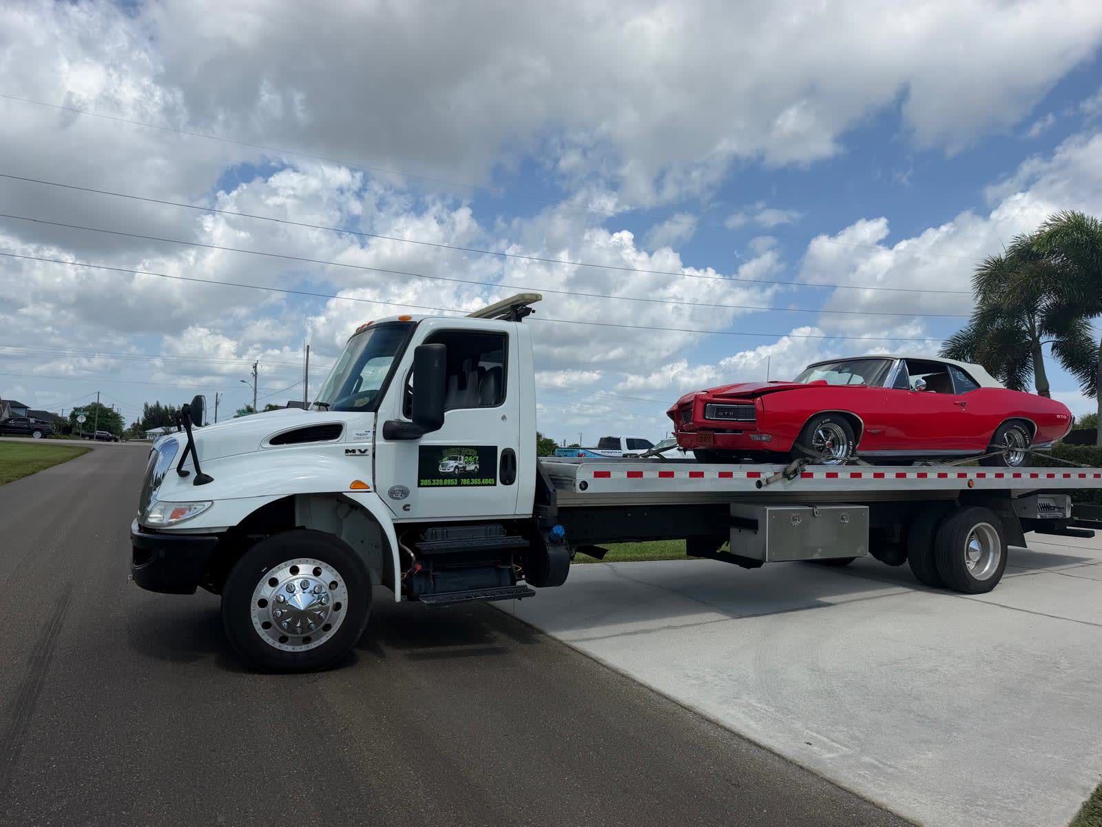 Brayan Towing flatbed truck loading a classic Pontiac GTO in Cape Coral